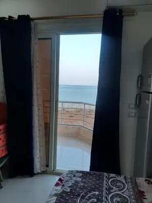 a bedroom with a view of the ocean through a sliding glass door at Casablanca beach family suites in Hurghada