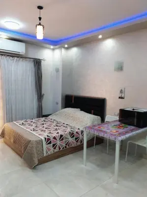 a bedroom with a bed and a table in it at Al makramia Compound in Hurghada