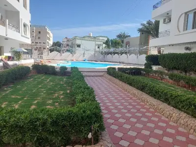 a pathway leading to a swimming pool in a building at Al makramia Compound in Hurghada