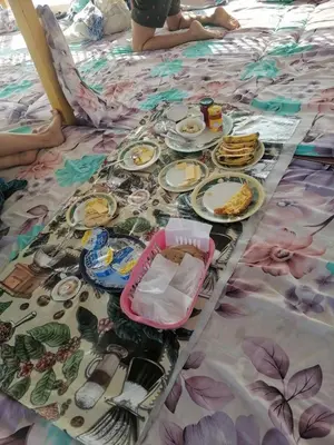 a table with plates of food on a bed at Aswan Felucca sailing boat and Hotel in Aswan