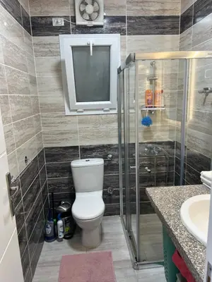 a bathroom with a toilet and a tv on the wall at Selena Bay Hurghada - Pink Apartment in Hurghada