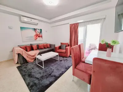 a living room with a couch and a table at Selena Bay Hurghada - Pink Apartment in Hurghada