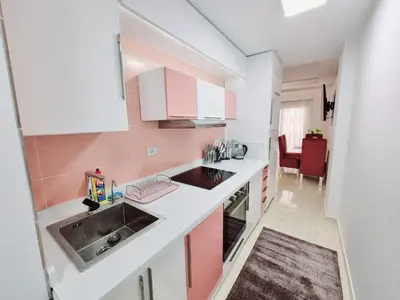 a kitchen with pink and white cabinets and a sink at Selena Bay Hurghada - Pink Apartment in Hurghada