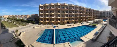a large swimming pool in front of a building at Selena Bay Hurghada - Pink Apartment in Hurghada