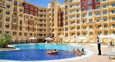 a man in a suit standing in a pool in front of a building at Floranza khamsin hurgada منتجع فلورنزا الغردقه in Hurghada
