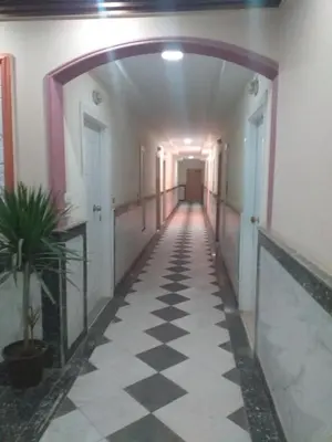 a hallway in a building with a checkered floor at شقة 327صغيرة جميلة هادئة وسط المدينة in Hurghada