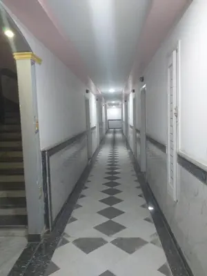 a hallway of a building with a checkered floor at شقة 327صغيرة جميلة هادئة وسط المدينة in Hurghada