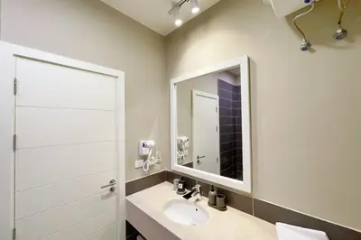 a bathroom with a sink and a mirror at Homey 3 BDR Townhouse Tawila El Gouna in Hurghada