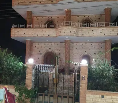 a building with a gate and a balcony at Nagar Villa For Rent in Luxor