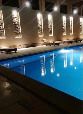 a swimming pool at night with benches and lights at Perfect for couples, Sunny & SeaView & Free Wi-fi in Hurghada