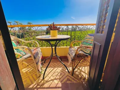 a small table and chairs on a balcony at Ramses Apartment in Luxor