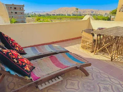 a bed on a balcony with a view of the desert at Ramses Apartment in Luxor