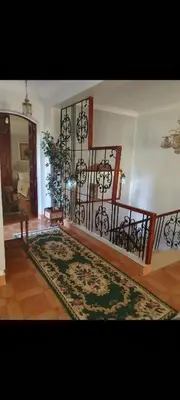 a living room with a staircase and a rug at Soliman Villa in Luxor