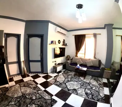 a living room with a couch and a checkered floor at hurghada home in Safaga