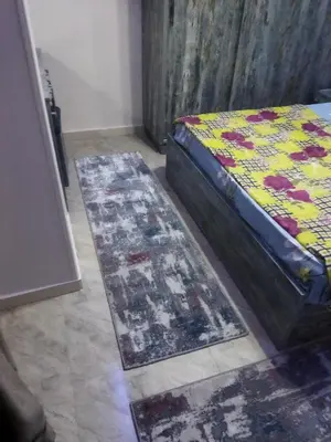 a bedroom with a bed and two rugs on the floor at Hurghada City Apartment2 in Hurghada