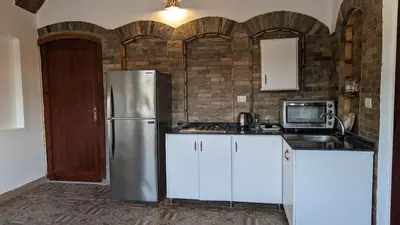 a kitchen with a stainless steel refrigerator and white cabinets at Yasmine Guest House in Luxor