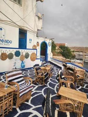 a patio with tables and chairs and a building at Endo Mando in Shellal