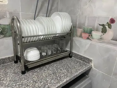 a kitchen counter with plates and bowls on a shelf at Tony HOUSE in Aswan