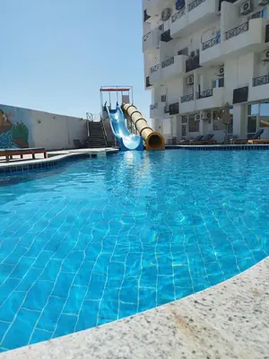 a swimming pool with a slide in front of a building at Tiba view in Hurghada