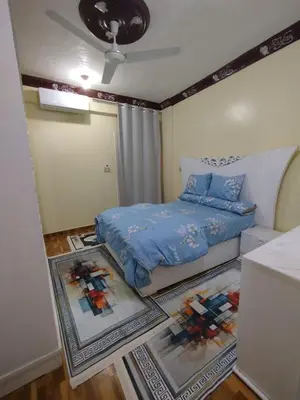 a small bedroom with a bed and a couch at شقة مميزة بجوار كورنيش النيل اسوان - عائلات فقط in Aswan