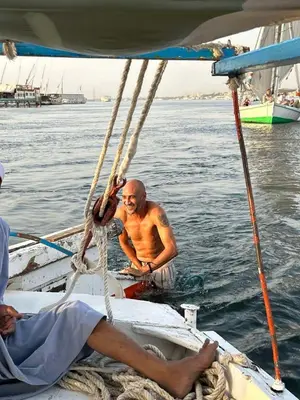 a man on a boat in the water at peace garden hostel & camp in Luxor