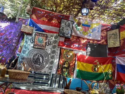 a bunch of flags are hanging on a wall at peace garden hostel & camp in Luxor