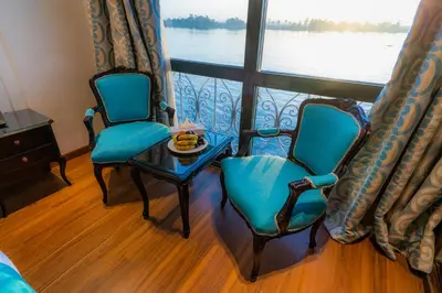 a room with two chairs and a table and a window at Nile Cruise City and Sea Adonis - Every Thursday from Luxor for 04 or 07 Nights - Every Monday from Aswan for 03 Nights in Luxor