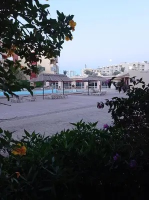 an empty beach with tables and chairs and buildings at Al-hambra in Hurghada