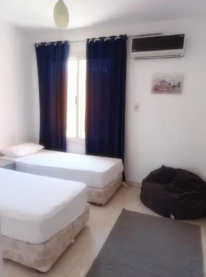 a room with two beds and a window at Al-hambra in Hurghada