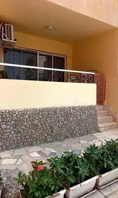 a house with a stone wall and some plants at Al-hambra in Hurghada