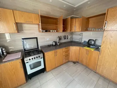 a kitchen with wooden cabinets and a stove top oven at Marvel lotus in Hurghada