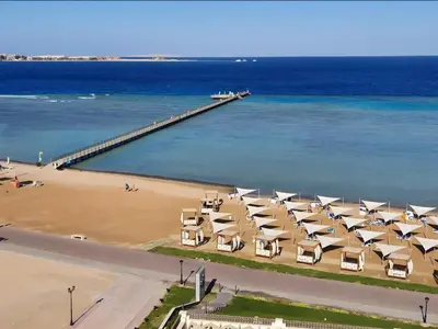 a beach with chairs and a pier in the water at luxury Beachfront Studio- Foreign Nationals Only in Hurghada
