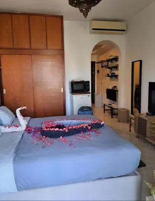 a bed with red flowers on it in a room at luxury Beachfront Studio- Foreign Nationals Only in Hurghada