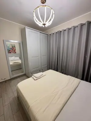 a bedroom with a large bed and a chandelier at Bali c 3 D in Hurghada