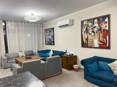 a living room with blue couches and a table at Bali c 3 D in Hurghada