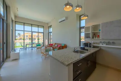 a kitchen with a sink and a living room at 4BR Villa with Private Pool Tawila Lagoon El Gouna in Hurghada