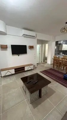 a living room with a flat screen tv on a wall at Bay View Sahl hasheesh Apartment Hurghada in Hurghada