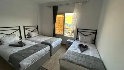 a room with two beds and a window at Bay View Sahl hasheesh Apartment Hurghada in Hurghada