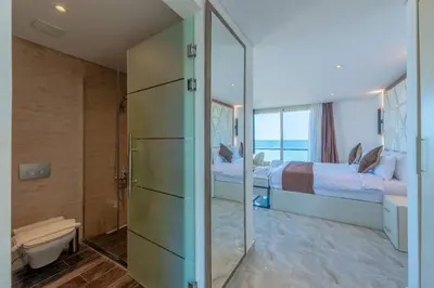 a bathroom with two beds and a shower with a mirror at Royal Villa on the beach in Hurghada