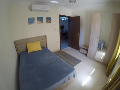 a bedroom with a bed with a yellow pillow at Andalusia Resort - 2 Bedroom Apartment in Hurghada