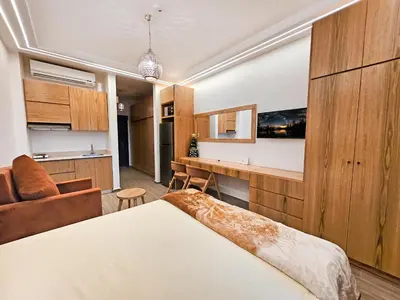 a bedroom with a bed and a desk in a room at Pool View Studio with Wi-fi, Smart TV, 3 pools & beach access in Hurghada