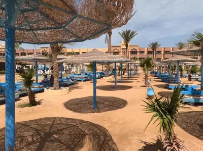 a beach resort with blue chairs and umbrellas at Pool View Studio with Wi-fi, Smart TV, 3 pools & beach access in Hurghada