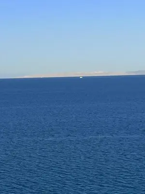 a large body of water with a boat in the distance at Juliana Beach Resort Hurghada in Hurghada