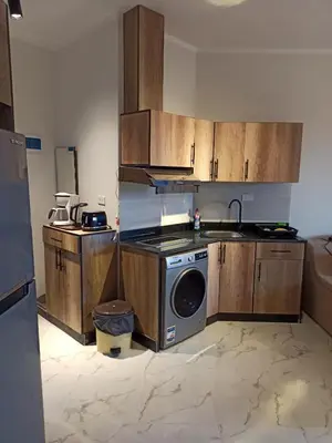 a kitchen with wooden cabinets and a washing machine at Juliana Beach Resort Hurghada in Hurghada