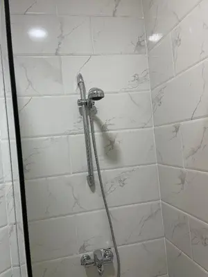 a bathroom with a shower with white tiles at Juliana Beach Resort Hurghada in Hurghada