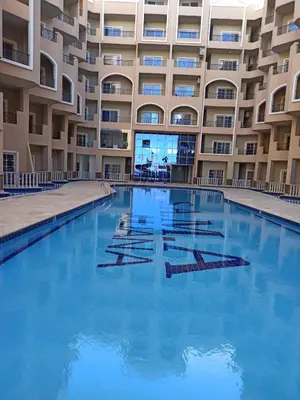a swimming pool in front of a building at Juliana Beach Resort Hurghada in Hurghada