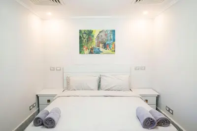 a bedroom with a white bed with two purple towels on it at MB1-1-104 in Hurghada