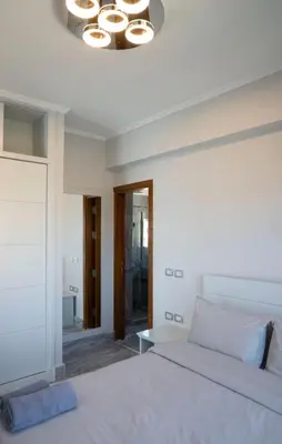 a bedroom with a white bed and a chandelier at MB1-1-104 in Hurghada