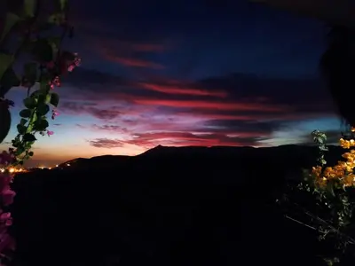 a sunset in the mountains with a red sky at Gabawy Garden Privatzimmer 2 Einzelbetten in Luxor