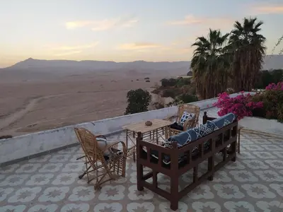 a patio with a table and chairs and a view of the desert at Gabawy Garden Privatzimmer 2 Einzelbetten in Luxor